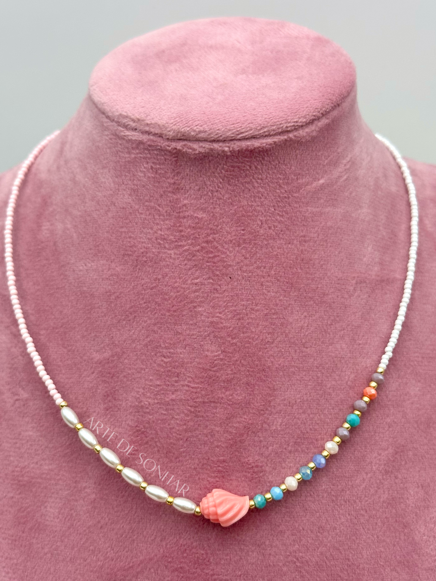 Colar de missangas brancas e pérolas com búzio coral