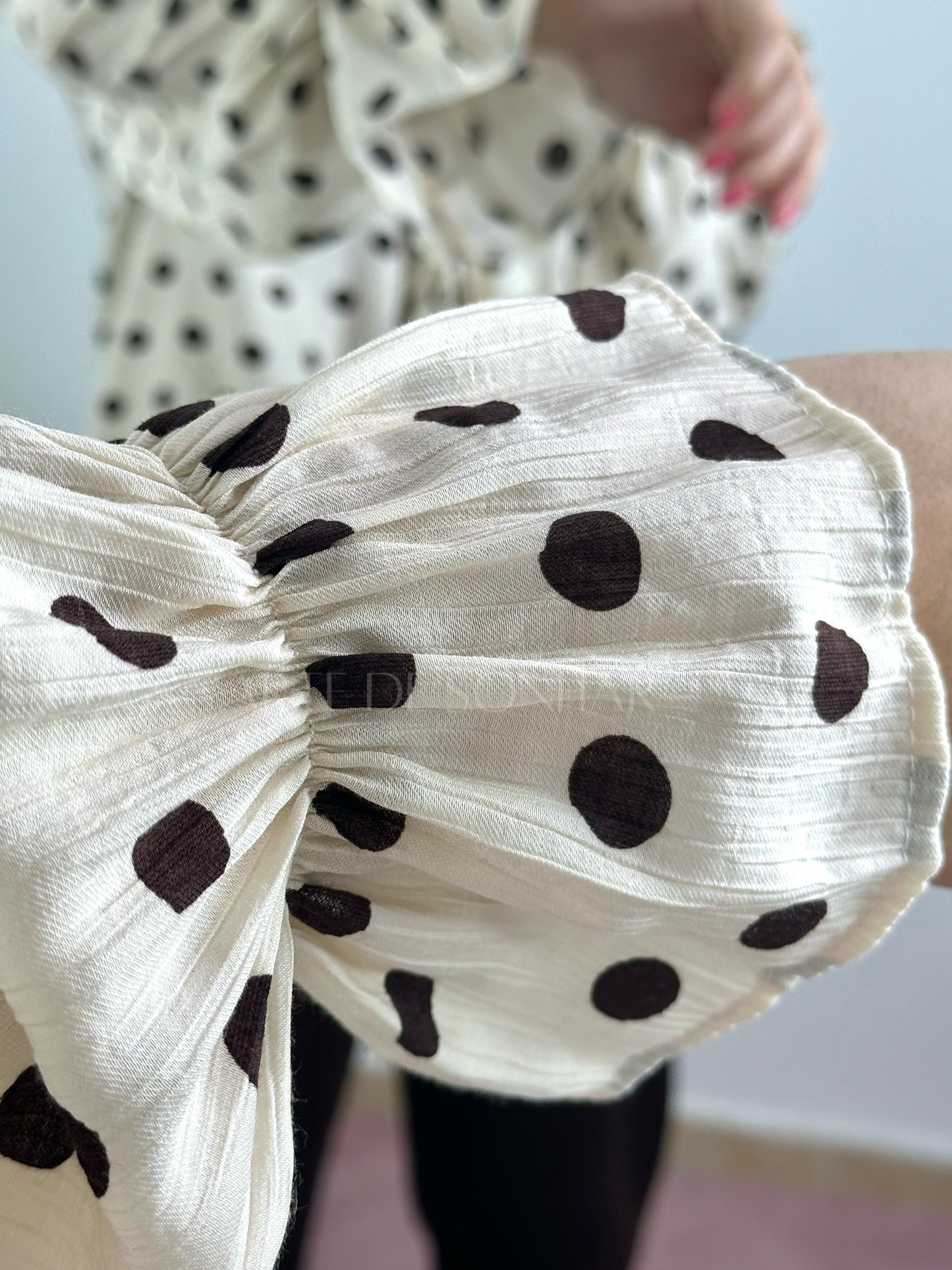 Blusa bege de bolinhas castanhas com folhos