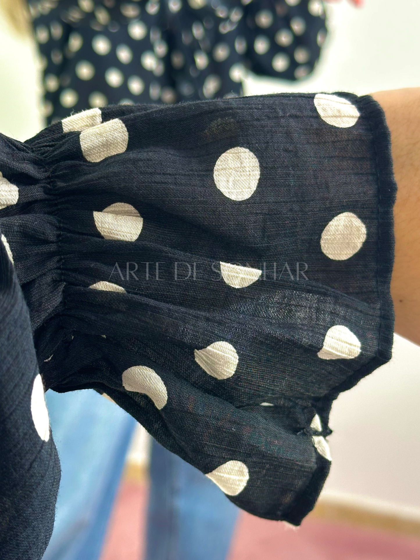 Blusa preta de bolinhas bege com folhos