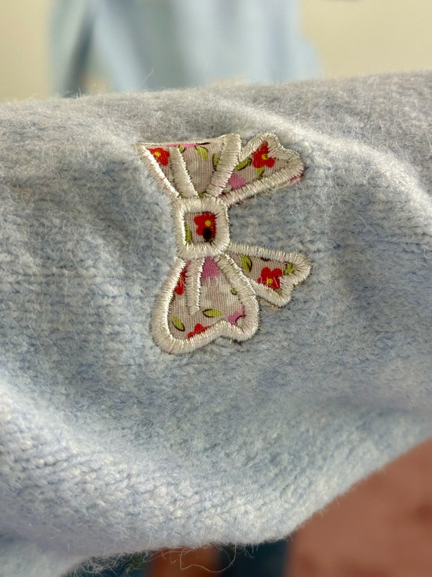 Camisola de malha azul com laços e flores