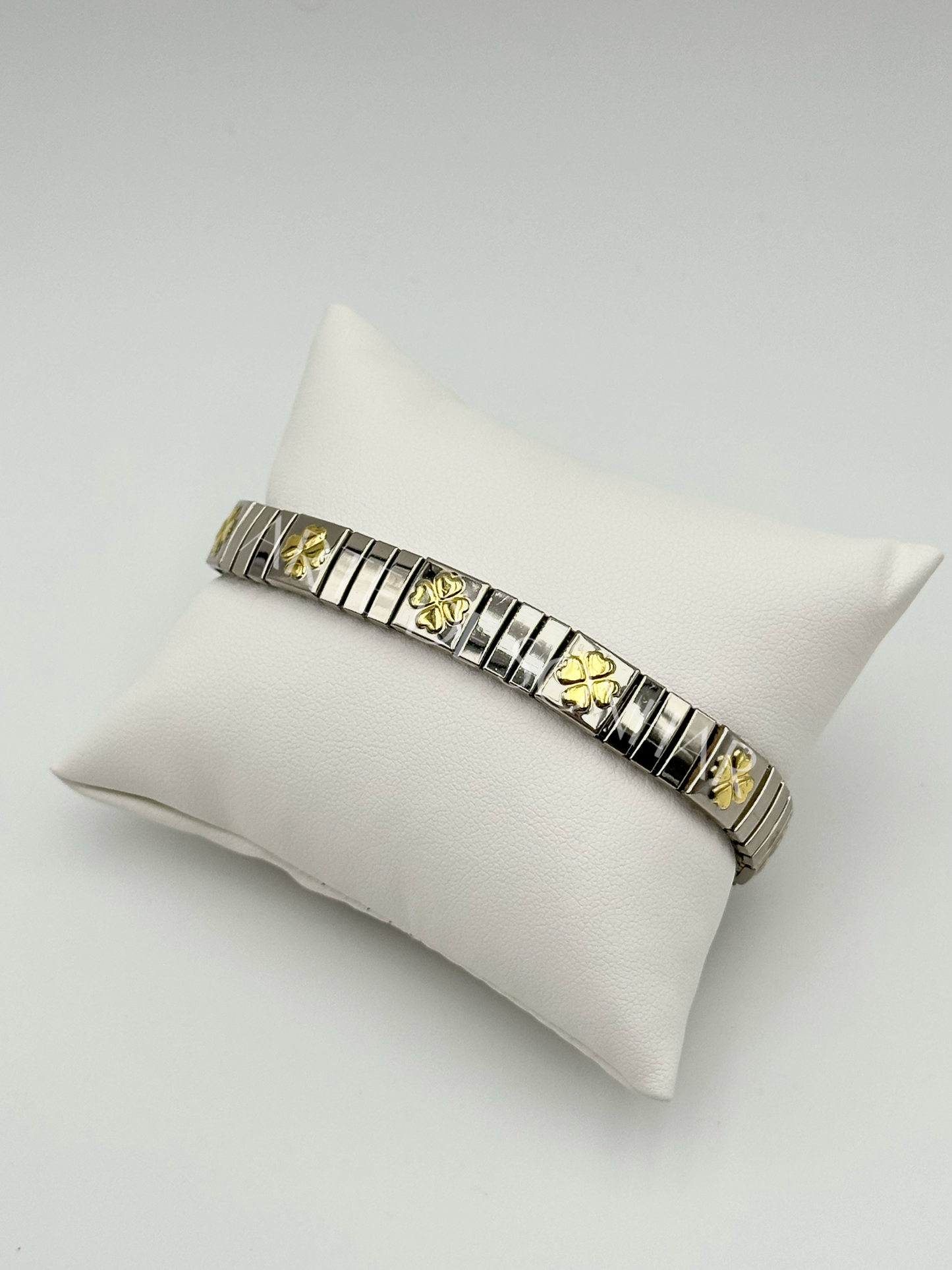 Pulseira prateada com trevo grande dourado