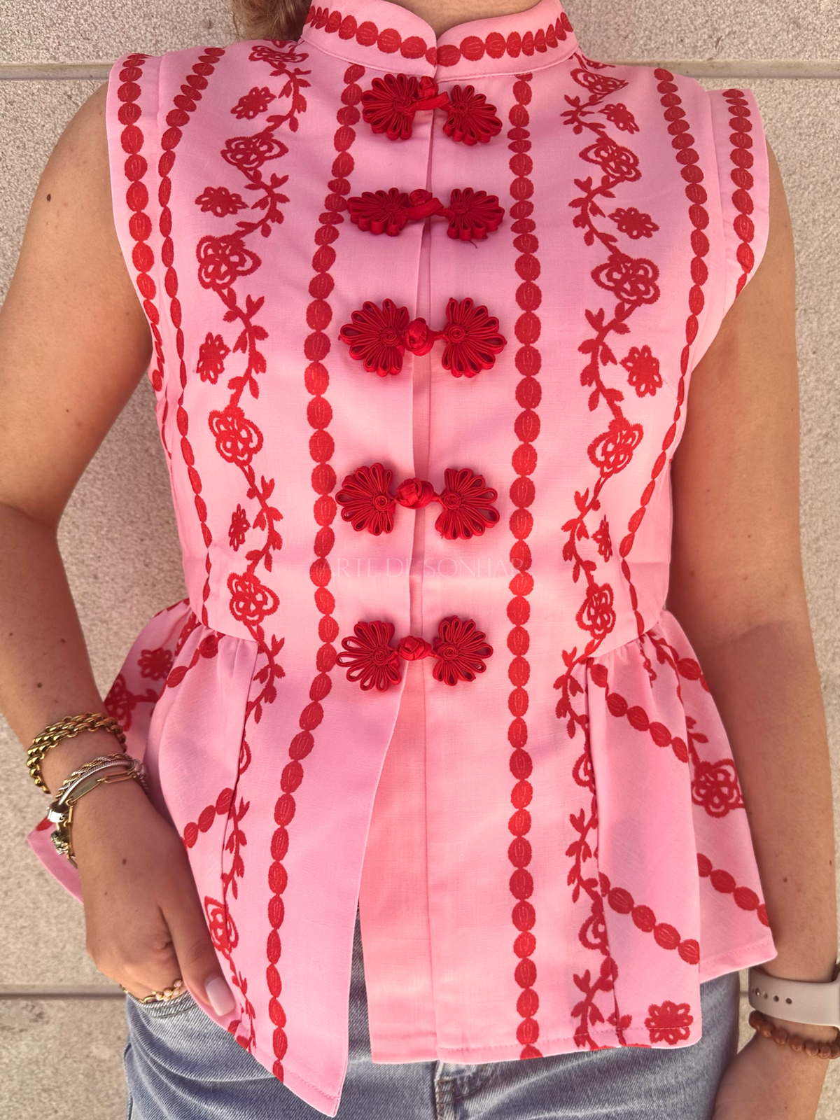 Colete rosa com bordados vermelhos
