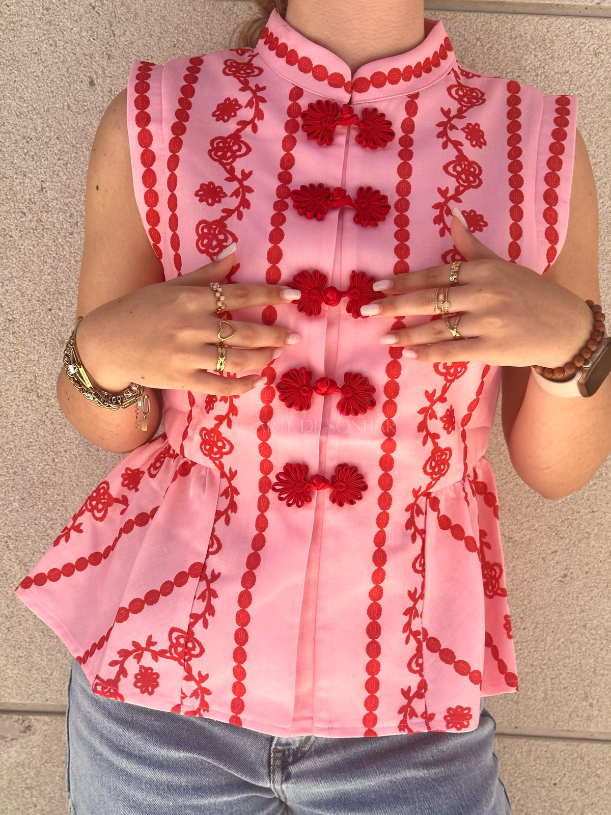 Colete rosa com bordados vermelhos